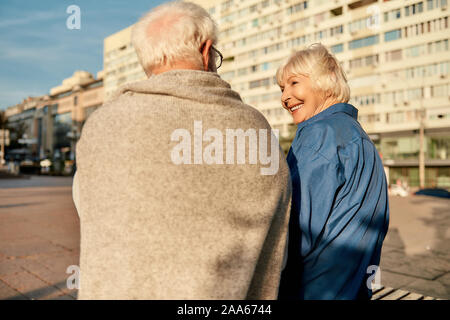 Was für ein schöner Tag! Rückansicht des Senior Paar in Freizeitkleidung auf der Bank sitzen zusammen und sprechen über etwas. Älterer Mann und Frau Stockfoto