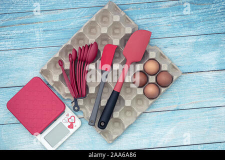 Flach von Oben nach Unten Blick auf Kuchen Backen backen Geschirr, rohe Eier und Zubehör auf Blau rustikal Hintergrund Stockfoto