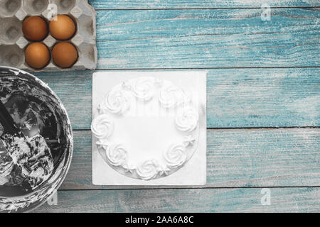 Flach der Weißen Kuchen Glasur und Kuchen Backen backen Geschirr und Zubehör auf Blau rustikal Hintergrund Stockfoto