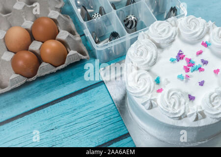 Kuchen Glasur, Kuchen backen, Besteck Zubehör und rohe Eier Küche auf dem Tisch Stockfoto