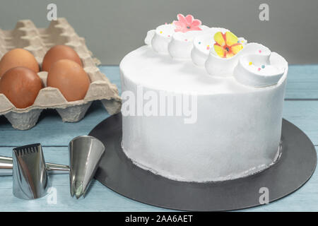 Kuchen Glasur, die backen Besteck Zubehör und rohe Eier Küche auf dem Tisch Stockfoto