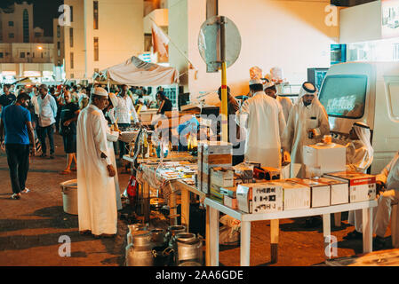 Männer in traditionellen thobes verkaufen und waren von der Straße Stände in Souq Al-Haraj, Doha, Qatar kaufen Stockfoto