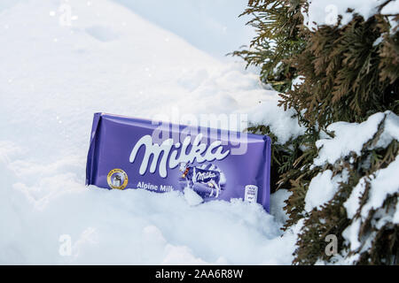 Eine Bar von Milka Mondelez Milch Alpenmilch Schokolade mit der lila Kuh, Winter, Schnee Stockfoto