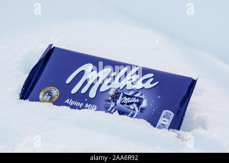 Eine Bar von Milka Mondelez Milch Alpenmilch Schokolade mit der lila Kuh, Winter, Schnee Stockfoto