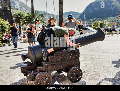 Montenegro, 20, 27, Sept 22, 2019: Frau umarmen dekorative Cannon und in die Altstadt von Kotor posing Stockfoto