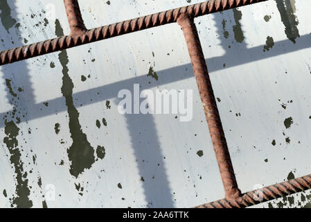 Alte Fenster durch weiße Farbe hinter einem rostigen Braun bars an einem sonnigen Tag gemalt. Zusammenfassung Hintergrund Stockfoto