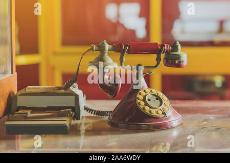Eine rote telehones Drehgeber mit Staub und Kratzern und Kreditkarte Maschine in den alten Zeiten auf einer Glasvitrine in einem alten Gold shop in so platziert Stockfoto