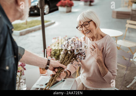 Schöne fröhliche Frau, glücklich einen Blumenstrauß zu erhalten Stockfoto
