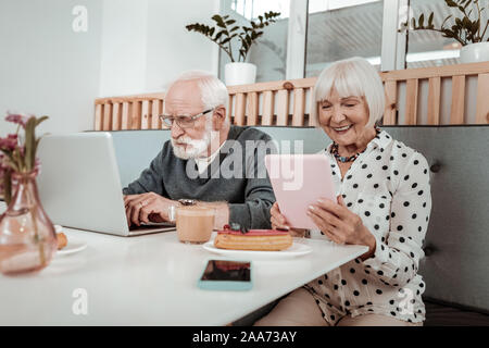 Angenehme ältere Menschen mit modernen digitalen Geräten Stockfoto