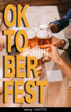 7/8-Ansicht von multikulturellen Freunden Anstoßen mit einem Bier in der Kneipe mit Oktoberfest Abbildung Stockfoto
