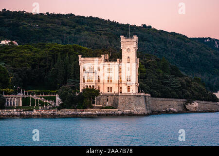 Dramatische Sicht auf die Touristen vor Ort Castello di Miamare (Schloss Miramare) in Triest, Italien, an der Mittelmeer Küste in Europa beim Sonnenuntergang. Vi. Stockfoto