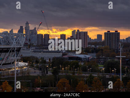 London, England, Großbritannien - 11 November, 2019: Die Sonne hinter der Silhouette der Stadt London und hohes Gehäuse des East End als vom Th gesehen Stockfoto