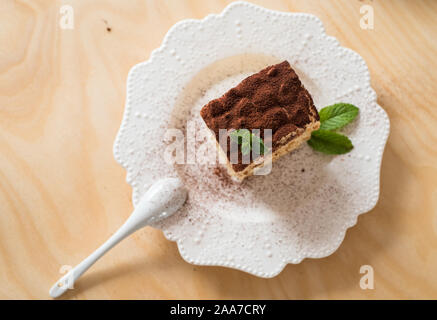 Tiramisu Kaffee Kuchen serviert auf einem weißen Teller Holz Hintergrund Stockfoto