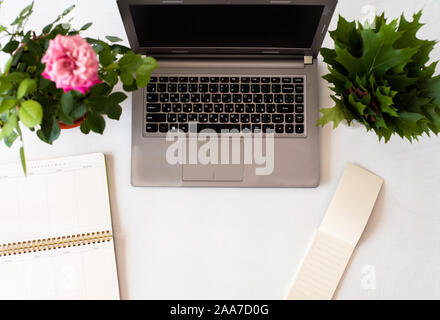 Arbeitsplatz mit Laptop, Tagebuch, Rosen und hölzernen Schreibtisch Stockfoto