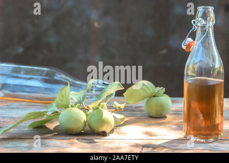 Apfelsaft in Flaschen abgefüllt. Immer noch leben, von achtlos verstreut halb leeren Flaschen mit Apfelessig. Zusammensetzung mit Brille, Dekorationen Zimt Stockfoto
