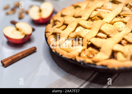 Apfelkuchen auf einem grauen Holztisch, mit Äpfeln, Zimt und Nüsse, selektiven Fokus Stockfoto