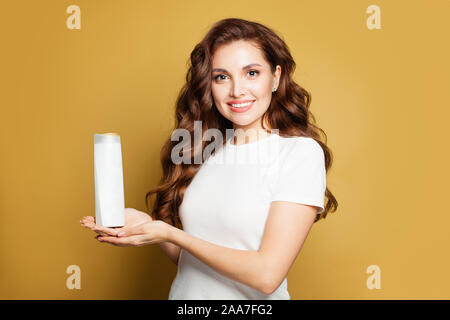 Lächelnde Frau mit weißen leeren Shampoo Tube in der Hand. Stockfoto