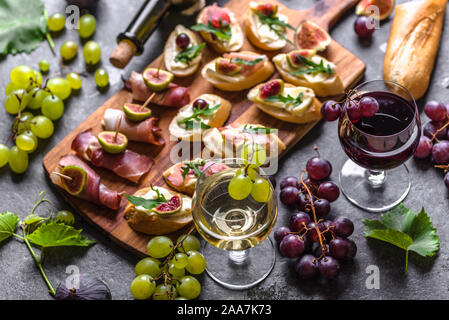 Traditionelle spanische Tapas, Wein snack Set - Lebensmittel aus Spanien oder italienische Antipasti: Bruschetta mit Käse, Fleisch und Obst. Kalte Vorspeisen und Wein gl Stockfoto