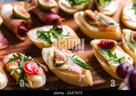 Traditionelle Tapas aus Spanien oder italienische Bruschetta mit Käse, Fleisch und Feigen. Party Food auf Catering Plattenteller. Stockfoto