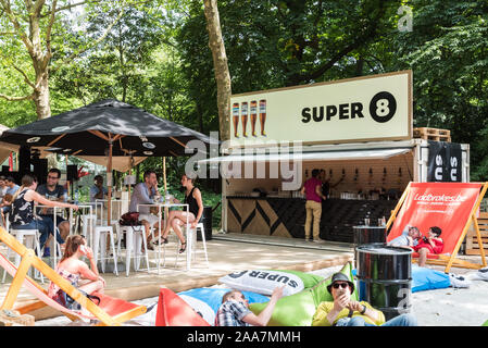 Brüsseler Altstadt/Belgien - 06 25 2019: Leute genießen einen Drink in einem Pop-up-bar Super 8 in der Sonne in der Parc de Bruxelles Warandepark an einem heißen Stockfoto