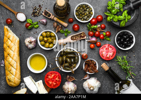 Italienisches Essen oder mediterrane Ernährung Hintergrund: Kräuter, Oliven, Öl, Tomaten, Brot, Käse und Wein Flasche