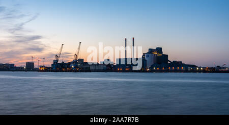 London, England, Großbritannien - 21 September, 2019: Die Sonne hinter die industrielle Landschaft von Tate und Lyle der Zuckerfabrik in Silvertown, inmitten der Apart Stockfoto