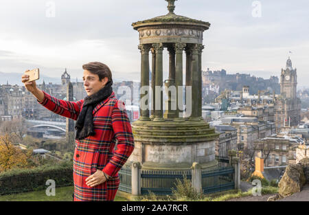 Edinburgh, Vereinigtes Königreich. 20 November, 2019 Im Bild: ein Tourist in Tartan gekleidet nimmt ein Foto von Edinburghs Skyline von Calton Hill in der Wintersonne. Credit: Rich Dyson/Alamy leben Nachrichten Stockfoto