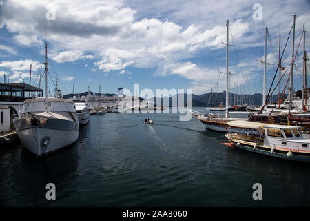 Ein motorisiertes Schlauchboot macht seinen Weg durch ein Meer von Yachten und Segelboote im Hafen von Marmaris, Türkei Stockfoto