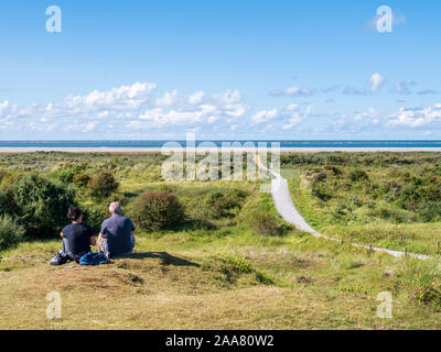 Menschen entspannend in Dünen und Fußweg zur Nordsee strand auf friesischen Insel Schiermonnikoog, Niederlande Stockfoto