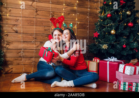 Zwei schöne junge Frauen, die ein Weihnachtsfest jedes anderen vorhandenen Stockfoto