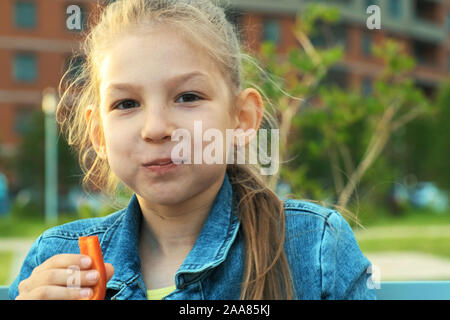 Porträt einer Schülerin das Essen von frischem Paprika. Gesunde Ernährung Schule Mittagspause Stockfoto