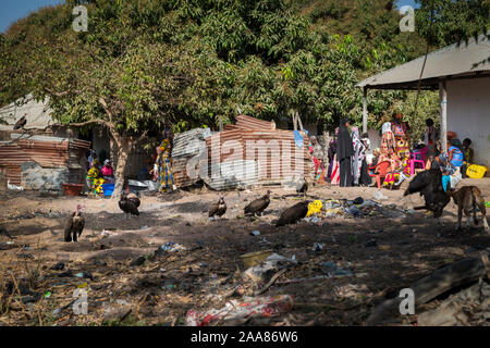 Gabu, Republik Guinea-Bissau - 11. Februar 2018: Die Menschen versammeln sich in der Nähe ein Haus in einem Slum am Rande der Stadt von Gabu, mit Schmutz in den Stree Stockfoto