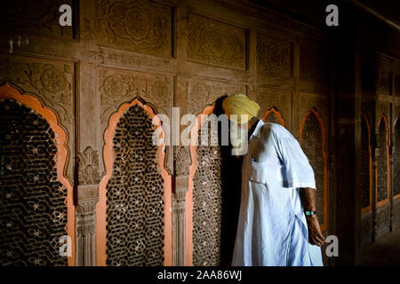 Bikaner, Rajasthan, Indien: ein Sikh Mann schaut durch ein hölzernes Gitter innerhalb des Junagarh Fort Stockfoto