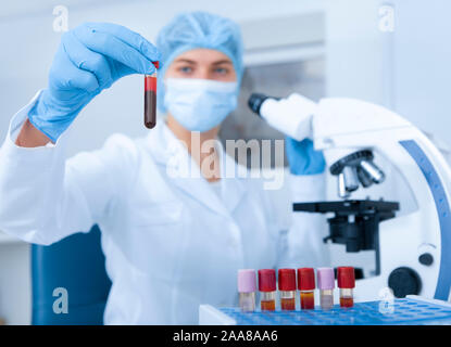 Junge Wissenschaftlerin holding Rohr mit Blutprobe Stockfoto