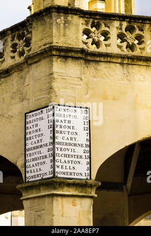 Stadt Kilometerstand Entfernungen sign on Market Cross in der Innenstadt. Shepton Mallet, Mendip, Somerset, England, Großbritannien, Großbritannien Stockfoto