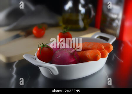 Salat Zutaten in weißen Schale. Tomaten, rote Radieschen und Möhren. Stockfoto