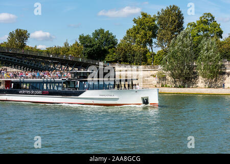 Kreuzfahrtschiff durch die Eiserne Brücke acrossing der Seine an einem sonnigen Tag in Paris, Frankreich. Stockfoto