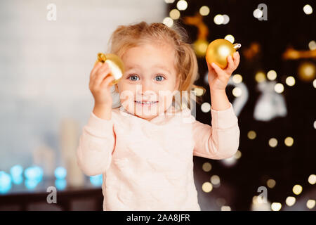 Süße kleine Mädchen spielen mit Christbaum Kugeln Stockfoto