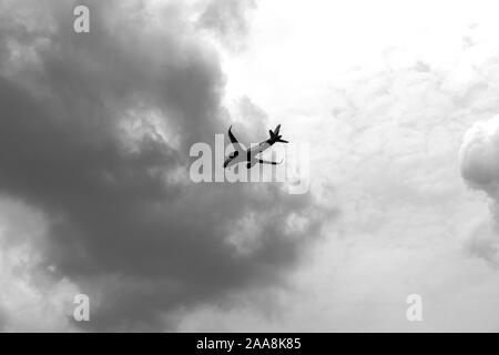 Kommerzielle Flugzeug fliegen in die dramatische Wolken. Zivile Luftfahrt Verkehr Travel Concept. Flugzeuge Sicht. Stockfoto