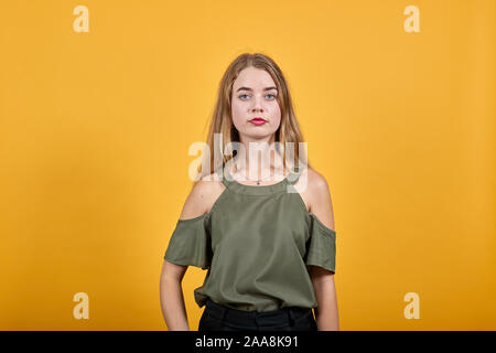 Junge lustige Frau mit schönen haki Shirt puffing Wangen mit lustigen Gesicht Stockfoto