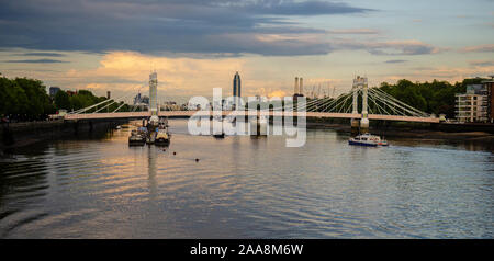 London, England, UK - 13. Mai 2014: Sonnenuntergang auf der Themse in Battersea in London, mit der Albert Bridge und die Skyline einschließlich St George. Stockfoto