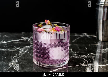 Pink Gin Tonic Cocktail mit Getrocknete Rosenknospen und Eis im Glas Schale. Bereit zu trinken. Stockfoto