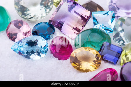 Sammlung mix bunte Edelsteine Schmuck auf weißem Sand. Stockfoto