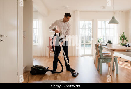 Geschäftsmann sein Haus Reinigung vor der Arbeit von zu Hause aus Stockfoto