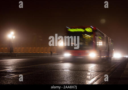 London, England, Großbritannien - 8. Januar 2009: Ein Bus kreuzt die Westminster Bridge in einer Winternacht, mit dem Palast von Westminster verblassen in Nebel hinter sich. Stockfoto