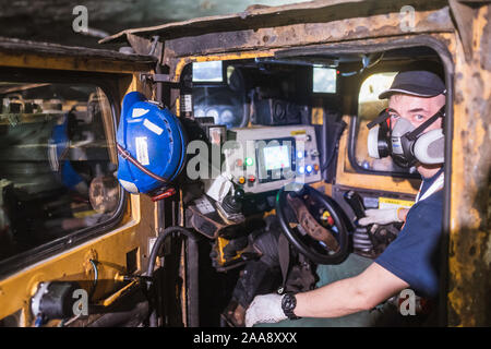 KAZMIERZOW, Polen - 8. OKTOBER 2019: Polkowice Sieroszowice Kupfermine gehört zu KGHM Polska Miedz. Frontlader Operator mit Maske auf seinem Fac Stockfoto