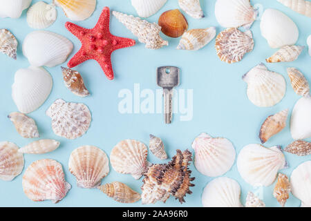 Key on a blue summer background with different shells and starfish Stockfoto
