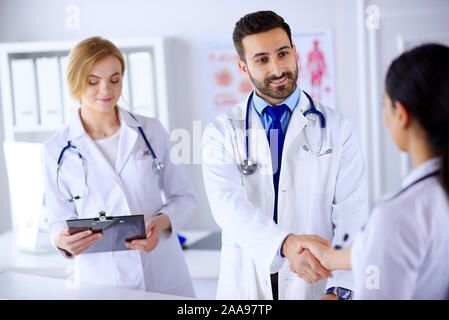 Gruppe junger Ärzte in der Klinik kommunizieren und Hände schütteln Stockfoto