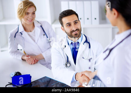 Ärzte im Büro besprechen Diagnose des Patienten. Treffen der Ärzte im Büro. Ärzte Hände schütteln Stockfoto