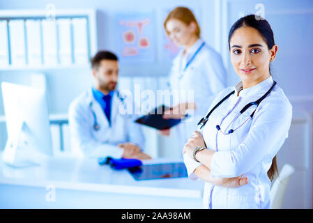 Zuversichtlich Ärztin vor der Mannschaft, in die Kamera lächeln suchen, Gemischtrassiges Team mit arabischen Ärztin Stockfoto